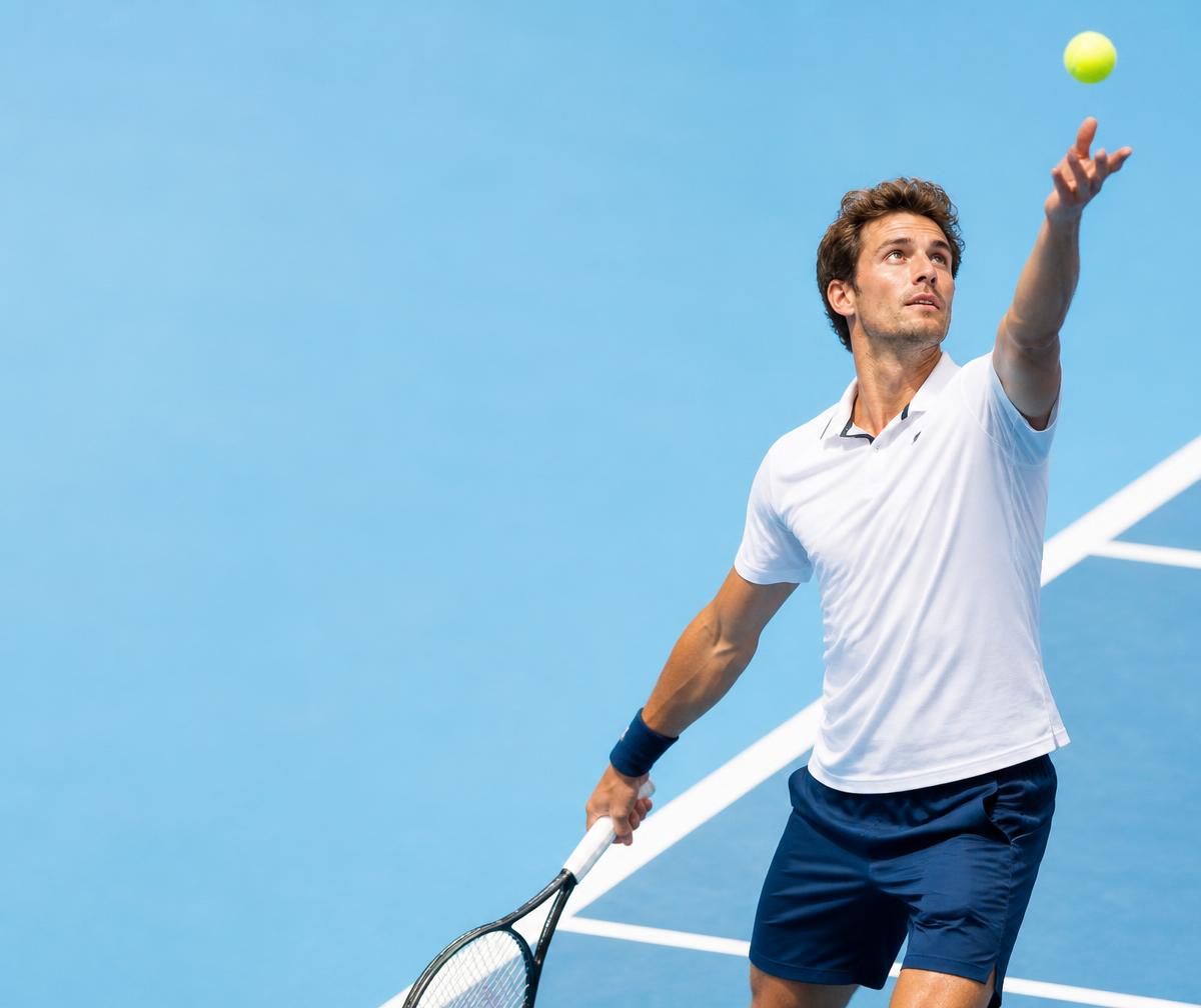 Tennis player serving on a blue court